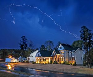 Lightning striking in the sky over a residential neighborhood