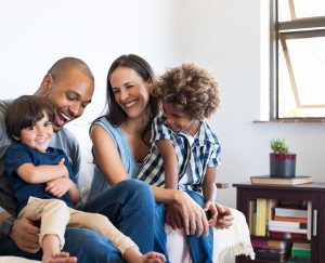 A family laughing on a sofa