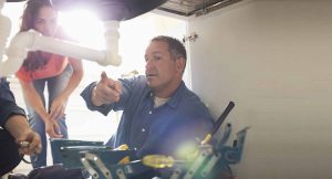 A worker showing a homeowner a problem with the sink