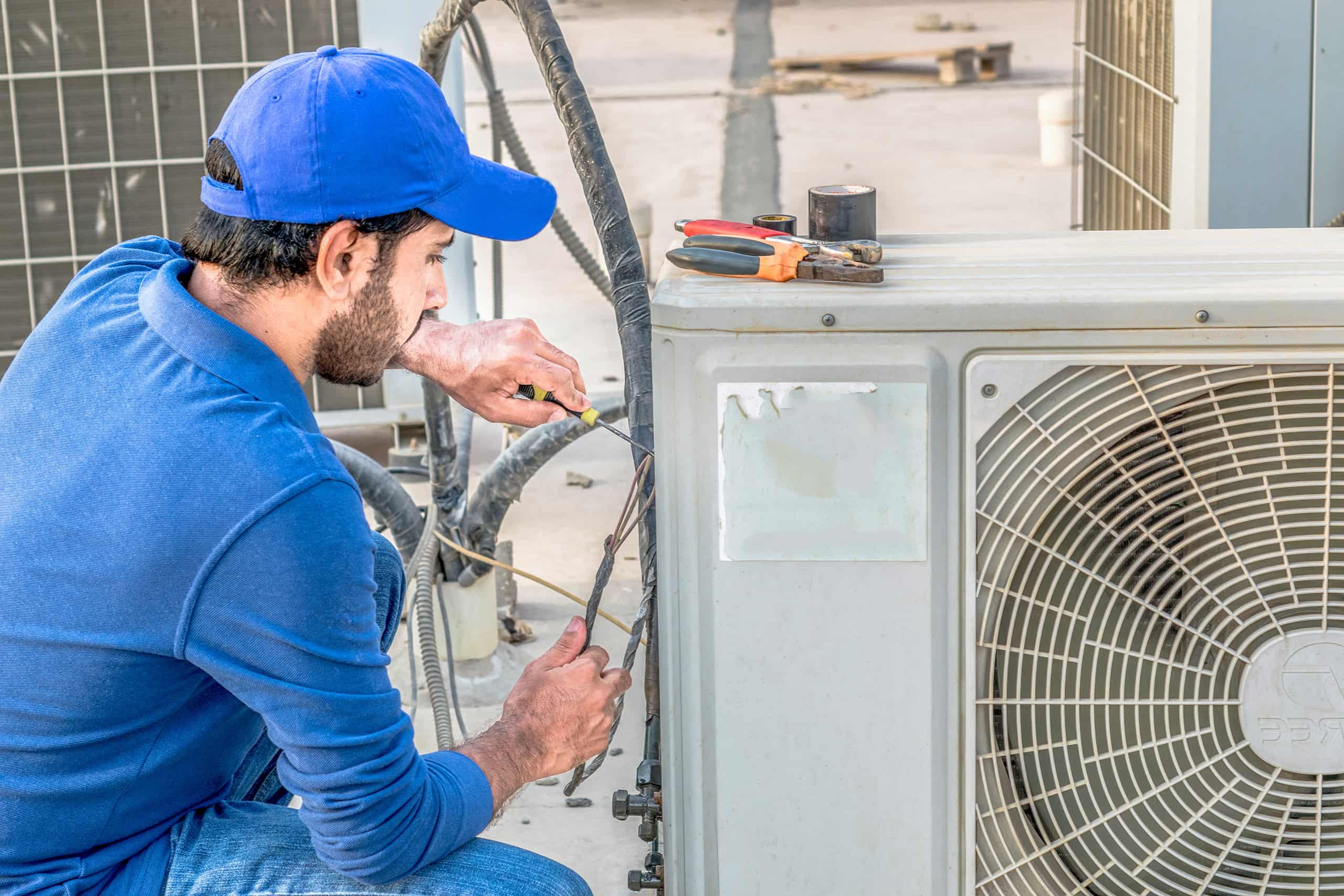 A man repairing an air conditioning unit